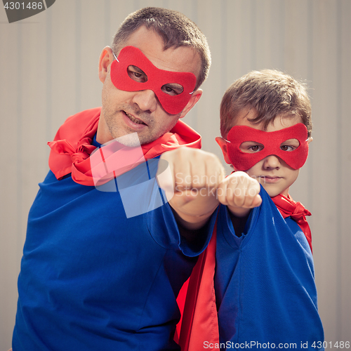 Image of Father and son playing superhero outdoors at the day time.