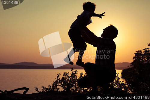 Image of father and son playing on the coast of lake