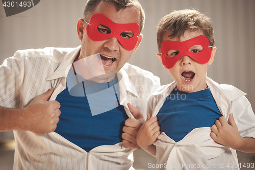 Image of Father and son playing superhero outdoors at the day time.