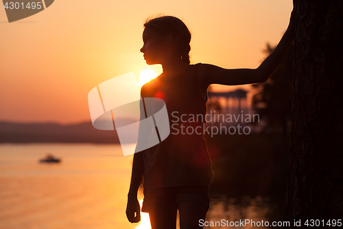 Image of Portrait of sad little girl standing on the beach
