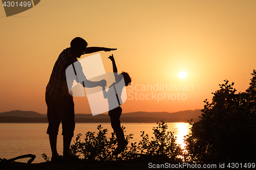 Image of father and son playing on the coast of lake