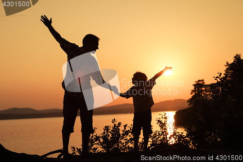 Image of father and son playing on the coast of lake