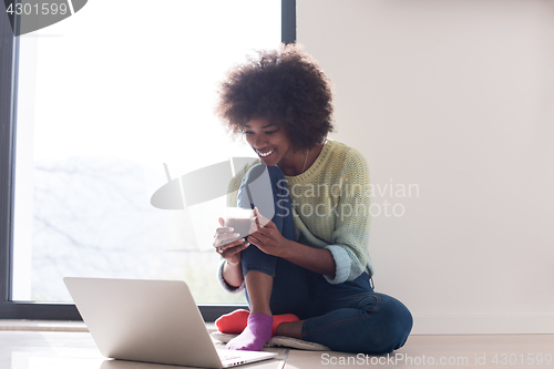 Image of black woman in the living room on the floor