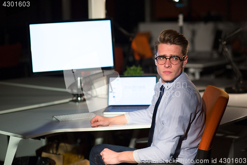 Image of man working on computer in dark office