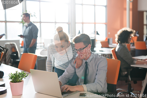 Image of Two Business People Working With laptop in office