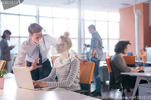 Image of Two Business People Working With laptop in office