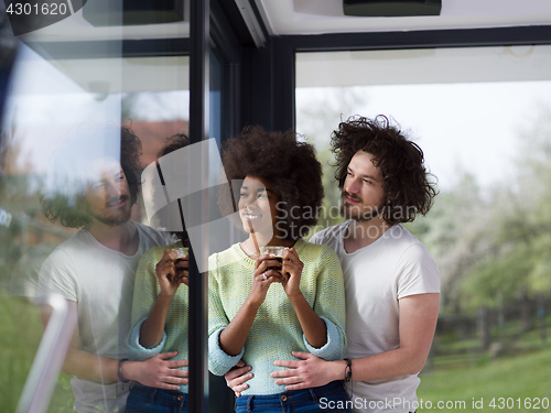 Image of happy multiethnic couple relaxing at modern home indoors