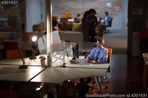 Image of man working on computer in dark office