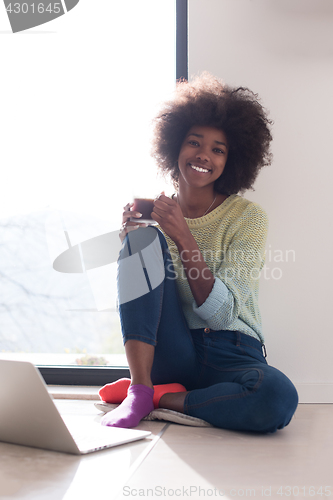 Image of black woman in the living room on the floor