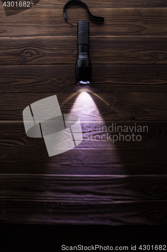 Image of Included flashlight on wooden texture