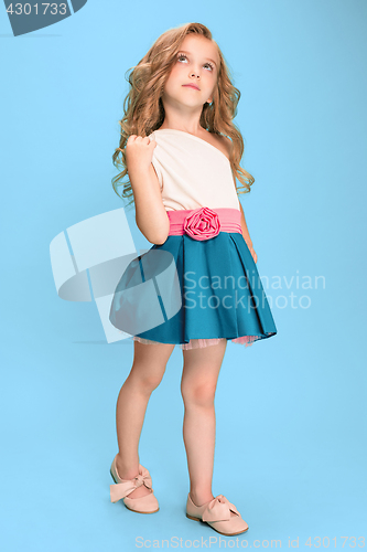 Image of Full length of beautiful little girl in dress standing and posing over blue background