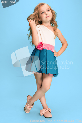 Image of Full length of beautiful little girl in dress standing and posing over blue background