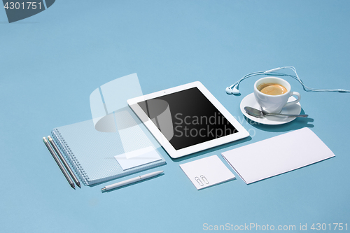 Image of The laptop, pens, phone, note with blank screen on table