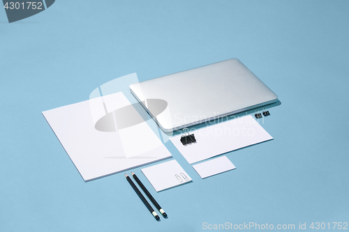 Image of The laptop, pens, phone, note with blank screen on table