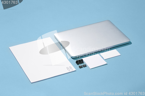 Image of The laptop, pens, phone, note with blank screen on table