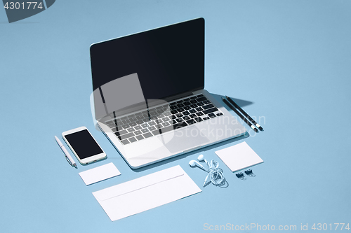 Image of The laptop, pens, phone, note with blank screen on table