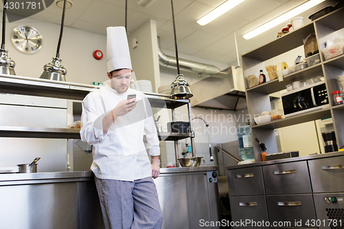 Image of chef cook with smartphone at restaurant kitchen