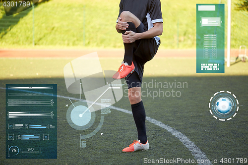 Image of soccer player stretching leg on field football