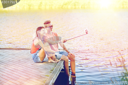 Image of happy teenage couple taking selfie on smartphone