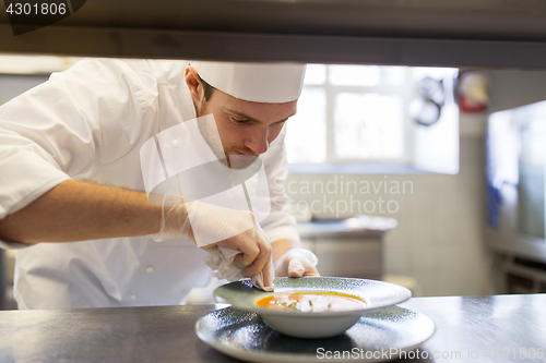 Image of happy male chef cooking food at restaurant kitchen