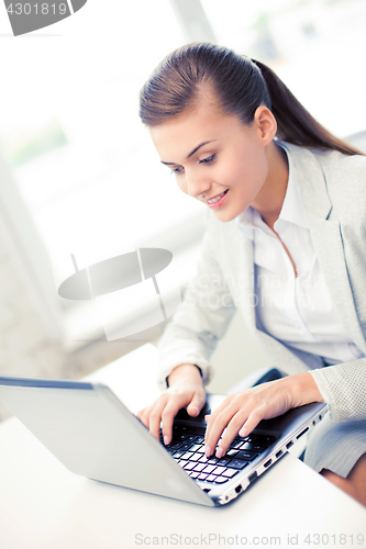 Image of businesswoman with laptop in office