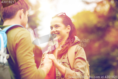 Image of happy couple with backpacks hiking outdoors