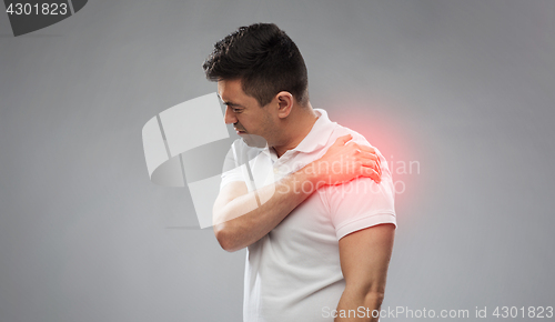 Image of unhappy man suffering from pain in shoulder