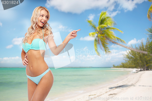 Image of happy smiling young woman in bikini on beach