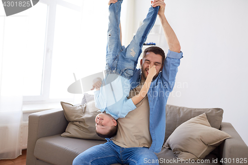 Image of father with son playing and having fun at home