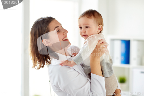 Image of happy doctor or pediatrician with baby at clinic