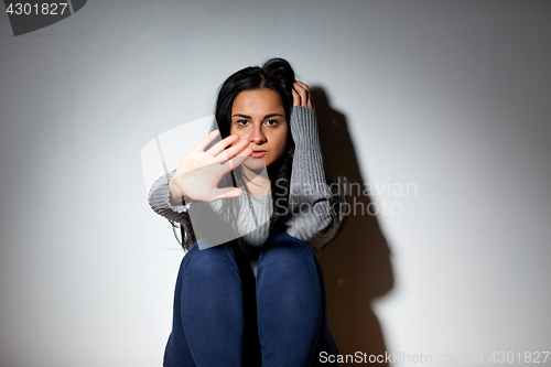 Image of unhappy woman crying on floor at home