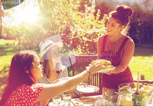 Image of happy friends having dinner at summer garden party