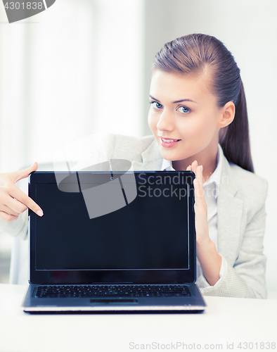 Image of businesswoman with laptop in office