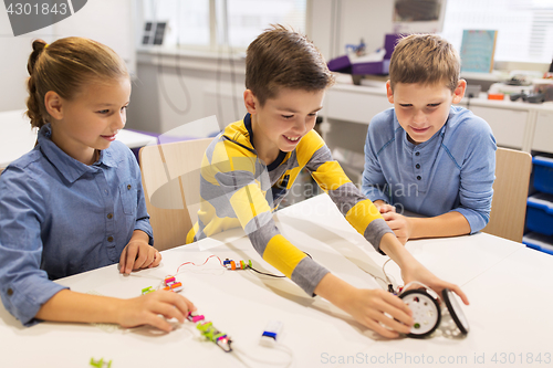 Image of happy children building robots at robotics school