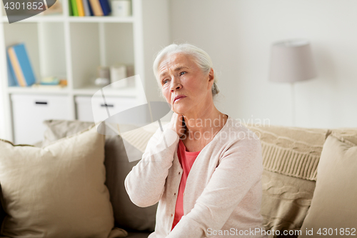 Image of senior woman suffering from neck pain at home