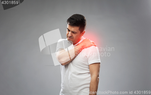 Image of unhappy man suffering from pain in shoulder