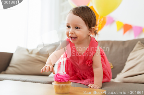 Image of baby girl with birthday cupcake at home party