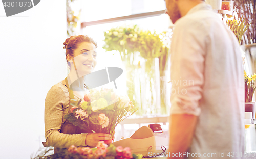 Image of smiling florist woman and man at flower shop