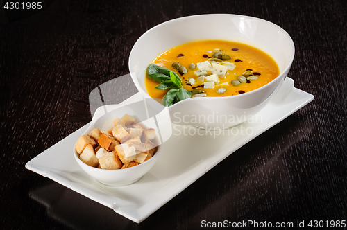 Image of Pumpkin and soup with cream and pumpkin seeds