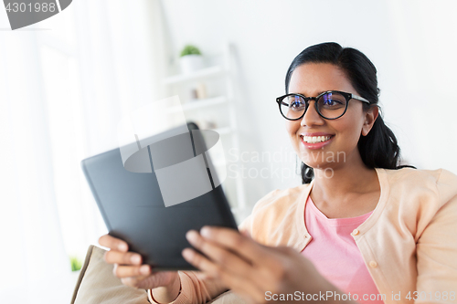 Image of happy indian woman with tablet pc at home