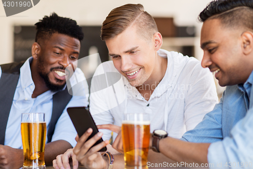 Image of male friends with smartphone drinking beer at bar