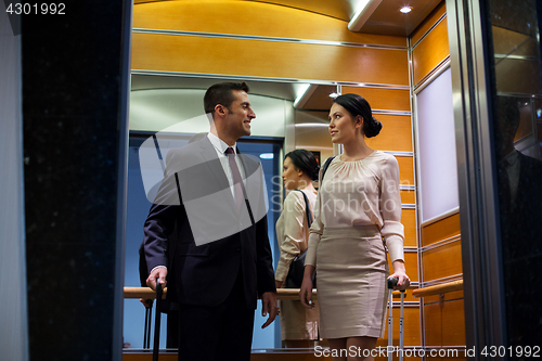 Image of business team with travel bags in hotel elevator