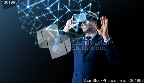 Image of businessman in virtual reality headset over black