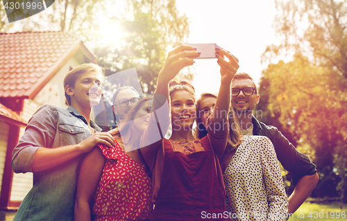 Image of friends taking selfie at party in summer garden