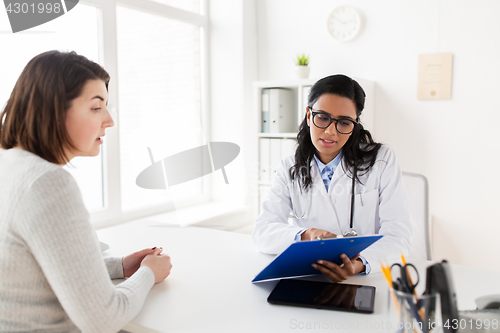 Image of doctor with clipboard and woman patient at clinic