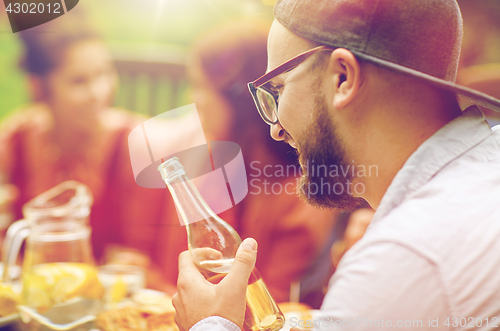 Image of happy man with beer friends at summer garden party