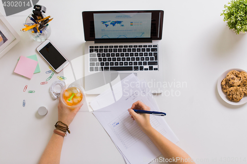 Image of woman hands with papers and cup of drink at office