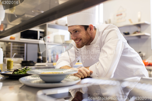 Image of happy male chef cooking food at restaurant kitchen