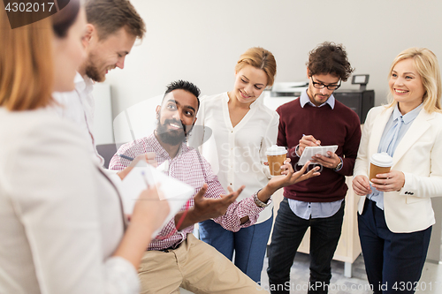 Image of happy business team drinking coffee at office