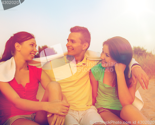 Image of smiling friends in sunglasses on summer beach